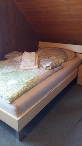 an unmade bed in a wooden room at Restaurant Blume in St. Gallen