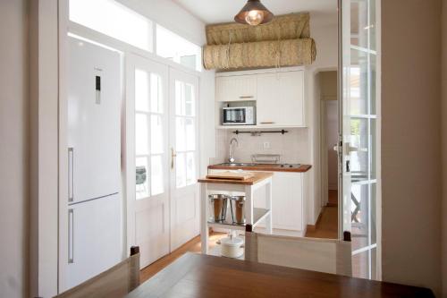 małą kuchnię z białymi szafkami i oknem w obiekcie Champion Duplex Terrace and Garage Old Town 6 pax w Sewilli