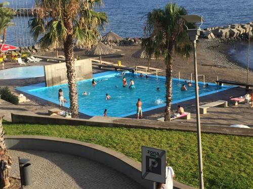 a group of people in a swimming pool at a resort at Rocha Mar 3M in Ribeira Brava