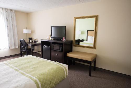 a hotel room with a bed and a mirror at Hope Hotel and Richard C. Holbrooke Conference Center in Fairborn