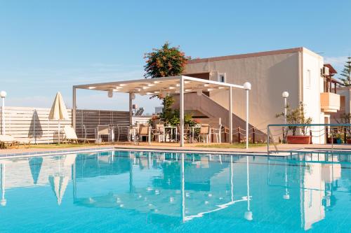 a swimming pool with a pavilion next to a building at Evdokia Αpartments & Dimitra Village in Agia Marina Nea Kydonias