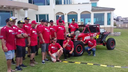 a group of people in red shirts standing next to a truck at La Mansión Residency Suites Ensenada in Ensenada