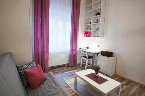 sala de estar con sofá, mesa y escritorio en Nati Apartman, en Budapest