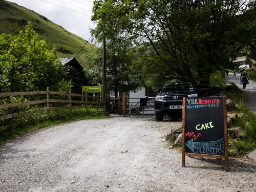 a sign for a cafe on a dirt road at YHA Helvellyn in Glenridding