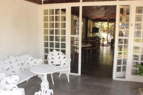 a room with white furniture and a table and chairs at Pousada Casa de Praia in Florianópolis