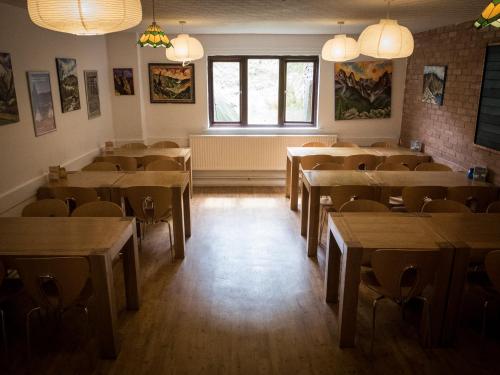 uma sala de jantar com mesas, cadeiras e janelas em YHA Helvellyn em Glenridding