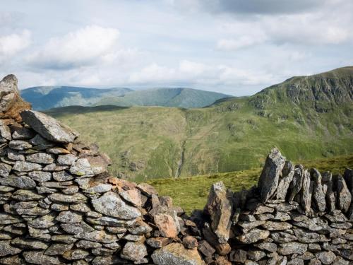 a stone wall with mountains in the background at YHA Helvellyn in Glenridding