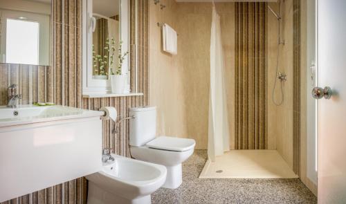 a bathroom with a toilet and a sink and a shower at Hostal San Miguel in Ponferrada