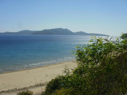 a sandy beach with the ocean in the background at Charly Point Villa in Methoni