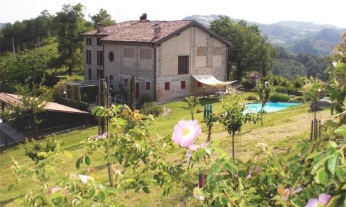 a house on a hill with a yard with flowers at Agriturismo Campo del Pillo in Pietradura