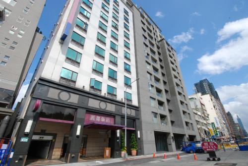un edificio alto en una calle de la ciudad con una señal de alto en Rido Hotel en Taipéi