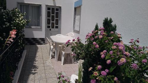 a patio with a table and flowers in front of a house at Casa da Amoreira in Luz de Tavira