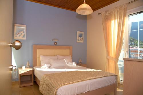 a bedroom with a bed and a large window at Arion Hotel in Skala Potamias
