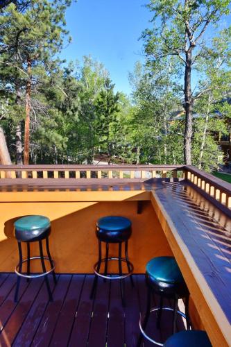 a deck with four stools on a wooden deck at Murphy's River Lodge in Estes Park
