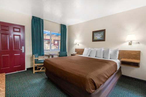 a hotel room with a large bed and a red door at Eureka Town House Motel - Historic Old Town in Eureka