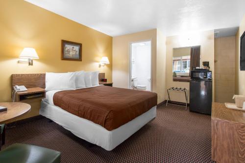 a hotel room with a bed and a kitchen at Eureka Town House Motel - Historic Old Town in Eureka