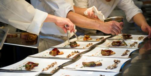 a group of chefs preparing food on plates on a table at Kalyon Hotel Istanbul in Istanbul