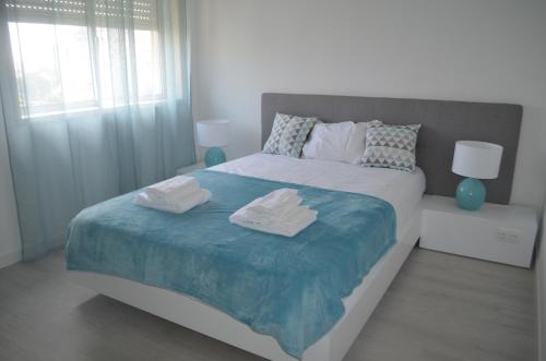 a bedroom with a large bed with towels on it at Modern and Cozy Apartment in Vila Nova de Gaia