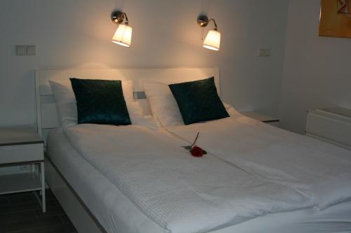 a large white bed with a red flower on it at Country Dream - Langholt 2 in Selfoss