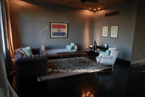 a living room with a couch and two chairs at Factoria Hotel in Asuncion