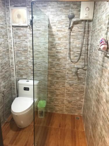 a bathroom with a toilet and a shower at Dang Sea Beach Resort - SHA in Nai Yang Beach