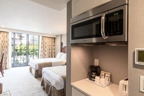 a hotel room with two beds and a microwave at Polynesian Residences Waikiki Beach in Honolulu