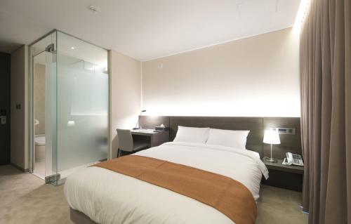 a hotel room with a large bed and a bathroom at Grand Mer Hotel Seogwipo Ocean in Seogwipo