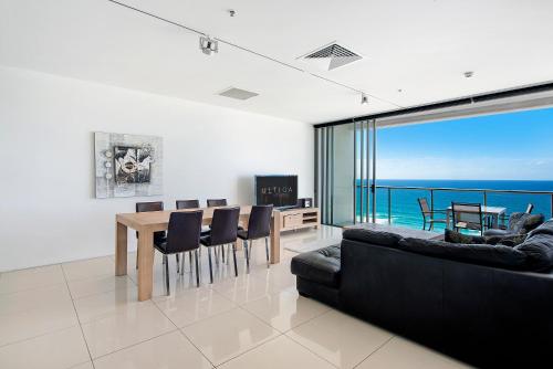a living room with a couch and a table and chairs at ULTIQA Air On Broadbeach in Gold Coast