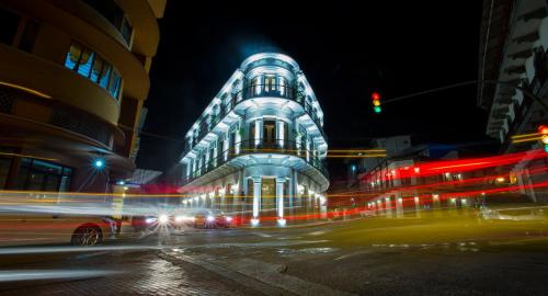 a building at night with traffic in the street at La Concordia - Boutique Hotel in Panama City