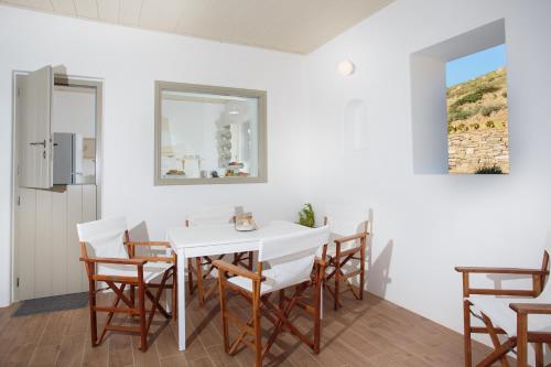 a dining room with a white table and chairs at Natura Villas Paros in Molos Parou