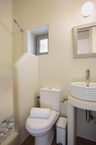 a white bathroom with a toilet and a sink at Natura Villas Paros in Molos Parou