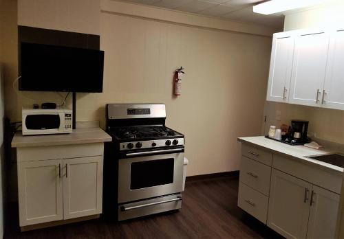 a kitchen with a stove and a microwave at Holiday Motel & RV Resort in Hope