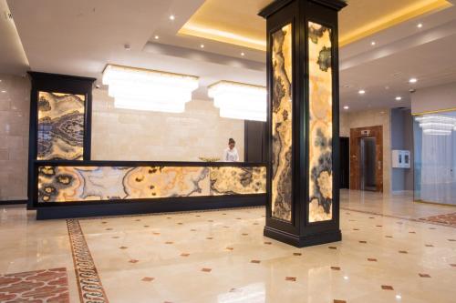 a person standing in a lobby with a wall at Best Western Plus Astana Hotel in Astana
