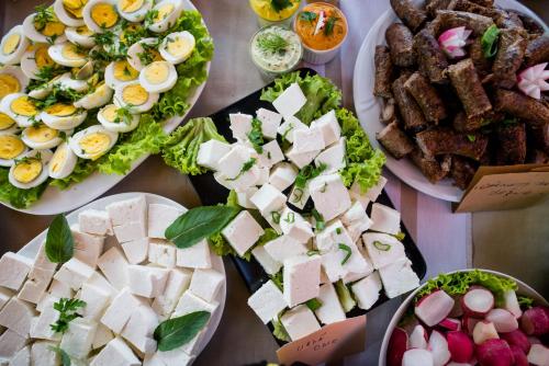 een tafel met borden eten met eieren en vlees bij Pension Bassen in Bazna