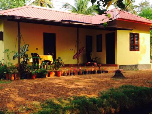 a house with a red roof and some plants at Munroe Eco Camp in Munroe Island
