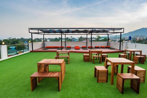 a deck with tables and benches on a roof at Phuket Marine Poshtel - SHA Plus in Chalong 