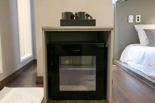 a room with a bed and a black refrigerator at Philstay Myeongdong Station in Seoul