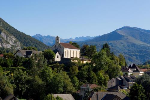 a small town with a church on a mountain at Hôtel Le Rive Droite & SPA in Lourdes