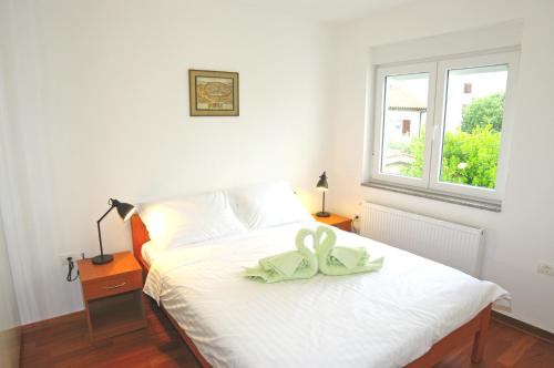 - une chambre dotée d'un lit blanc avec un oriel dans l'établissement Braće Ilić 1, à Fažana