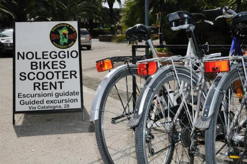 two bikes parked next to a sign on a street at Hotel Oasis in Alghero