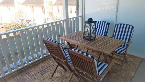 ein Holztisch und vier Stühle auf einem Balkon in der Unterkunft Haus Strandeck Apartment Meeresrauschen 12 in Göhren