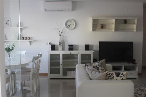 een woonkamer met een witte bank en een tv bij Anna - Maria Apartments in Albufeira