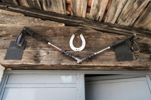 a wooden wall with a horseshoe and a door at Eco Garten Guest House in Shkodër