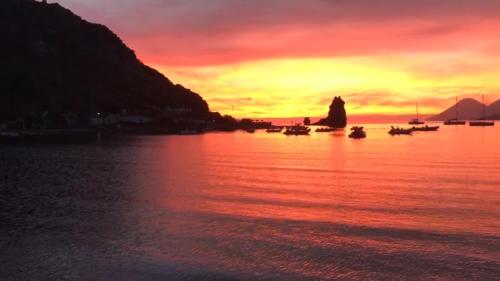 a sunset over a body of water with boats at Residence I Pagghiari Bungalow in Vulcano