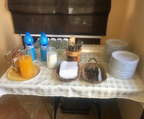 a table topped with plates and a glass of orange juice at Villa Larus in Palić