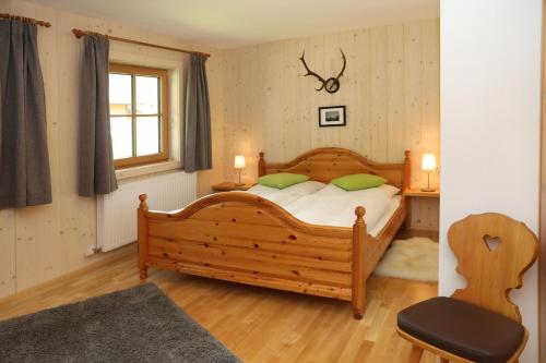 ローファーにあるFlatscherbauerのベッドルーム1室(木製ベッド1台、緑の枕2つ付)