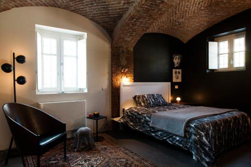 ドリアーニにあるCasamerla Doglianiのベッドルーム1室(ベッド1台、椅子1脚、窓2つ付)