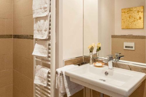 a bathroom with a white sink and a mirror at Palace am See in Tegernsee