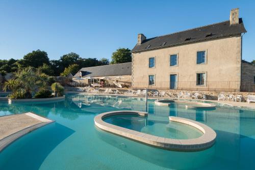 a large swimming pool with a building in the background at Camping de l'Orangerie de Lanniron in Quimper