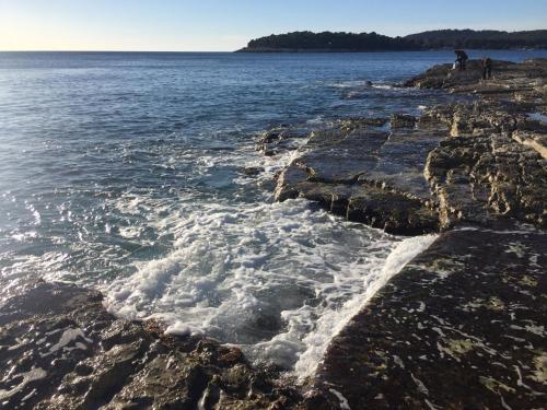 a body of water with waves crashing on the rocks at Monte Paradiso Panorama in Pula
